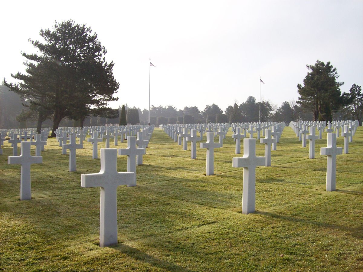 Kreuze auf Kriegsgräbern auf einer großen Wiese