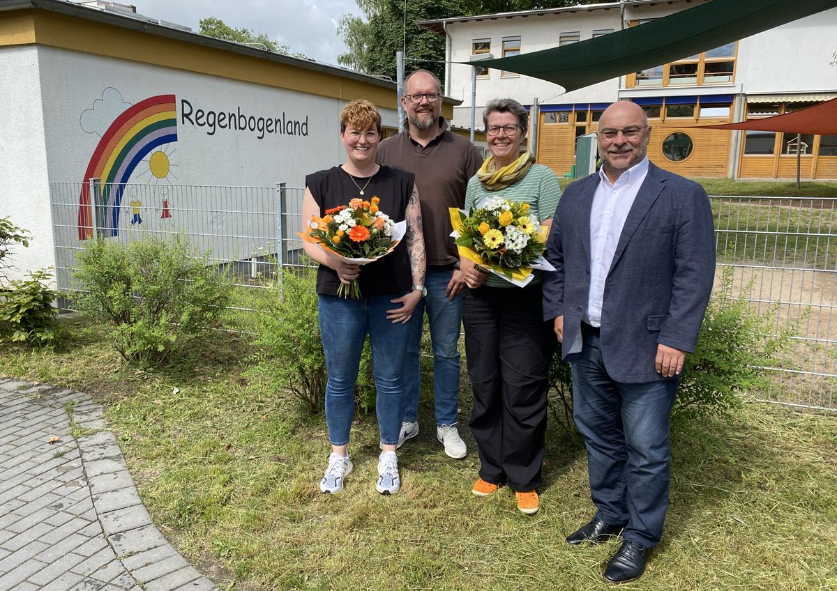 Die beiden Quereinsteigerinnen Julia Rüdinger und Corinna Bienhaus-Bamberger mit dem Leiter des Regenbogenlandes Wolfgang Reiter und Bürgermeister Jürgen Kirchner vor der Kita Regenbogenland